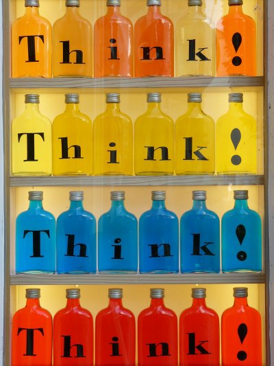 Rows of glass bottles filled with coloured water - labelled "Think"